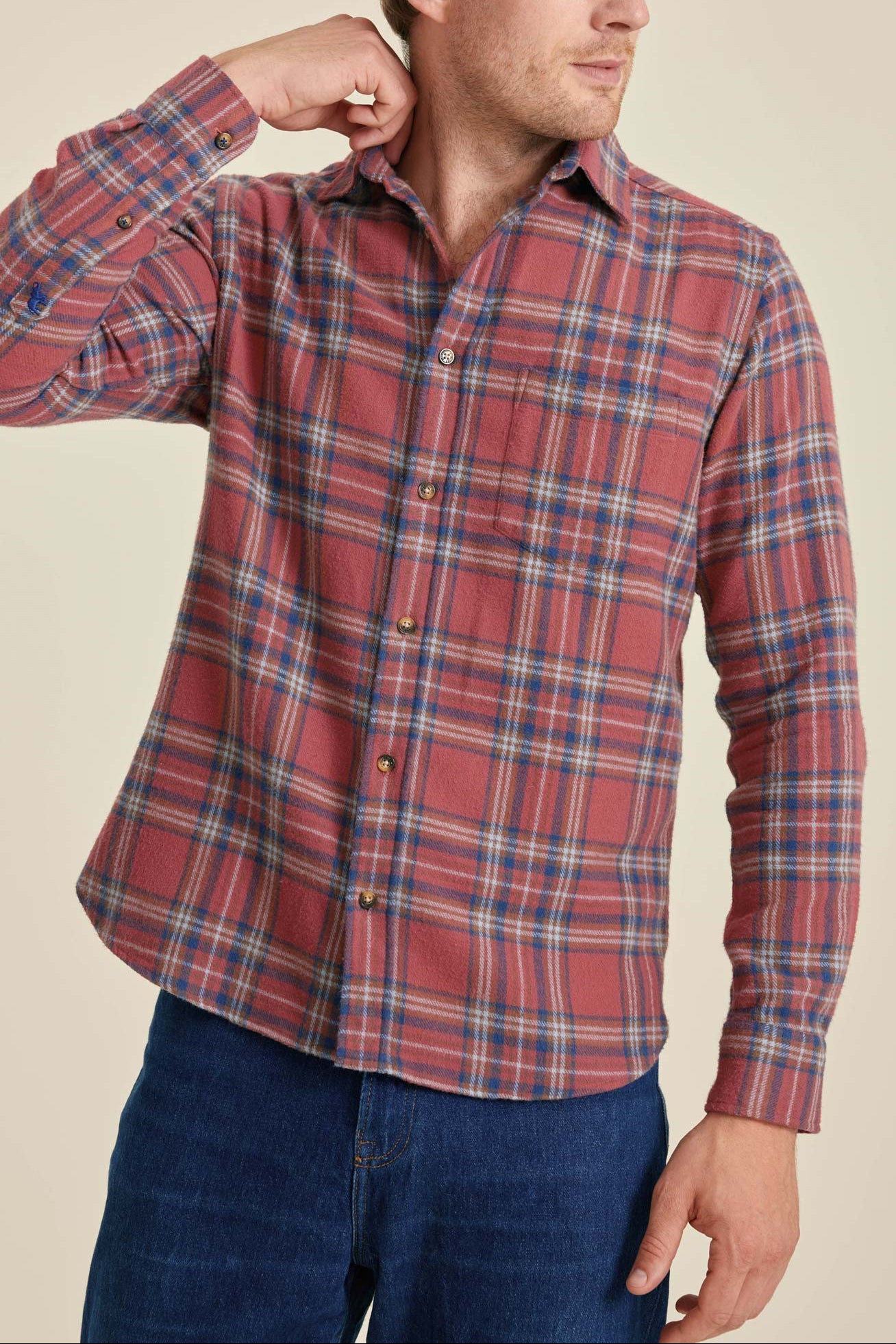 Man wearing a red plaid shirt against a beige background