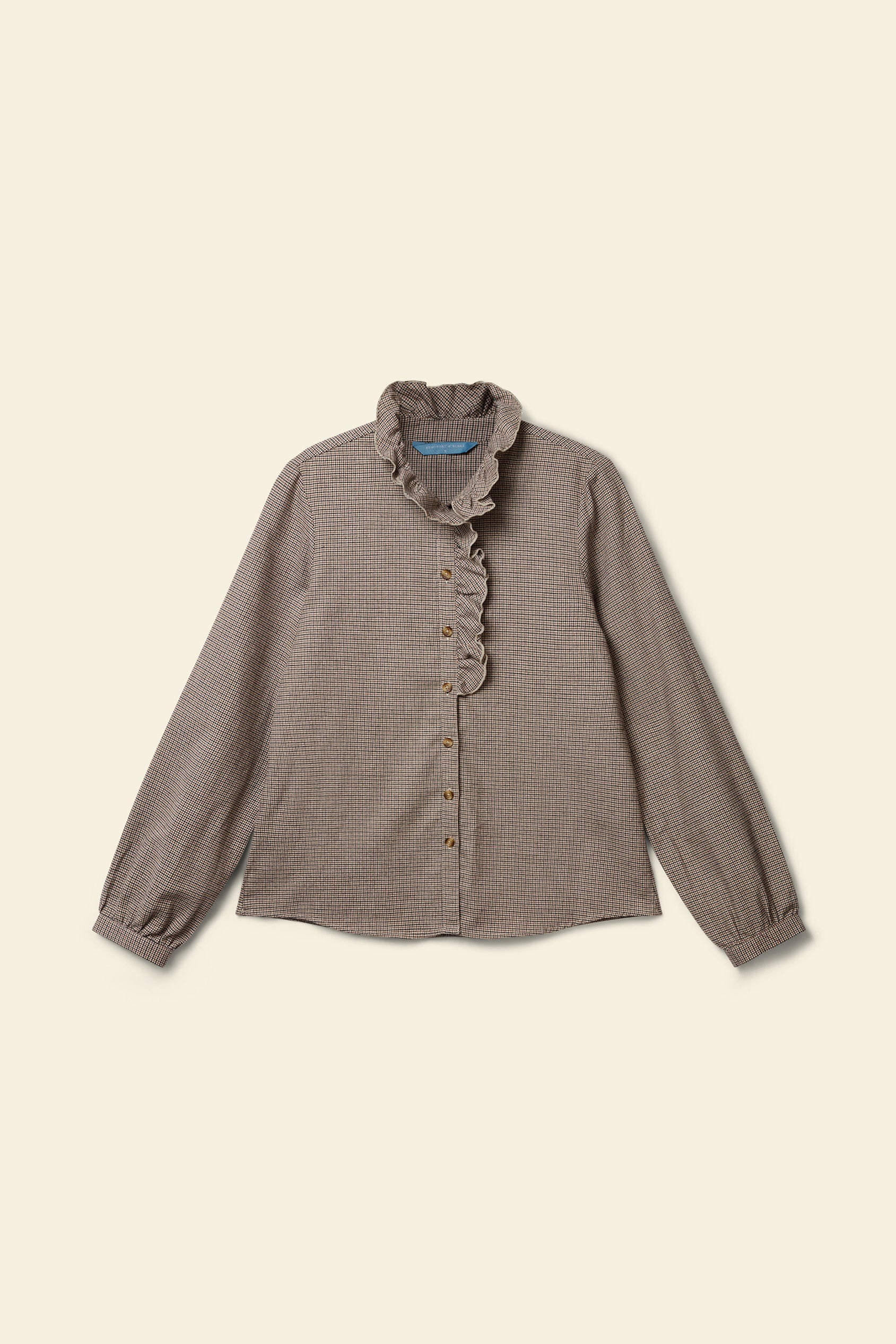 Brown blouse with ruffled collar on a beige background