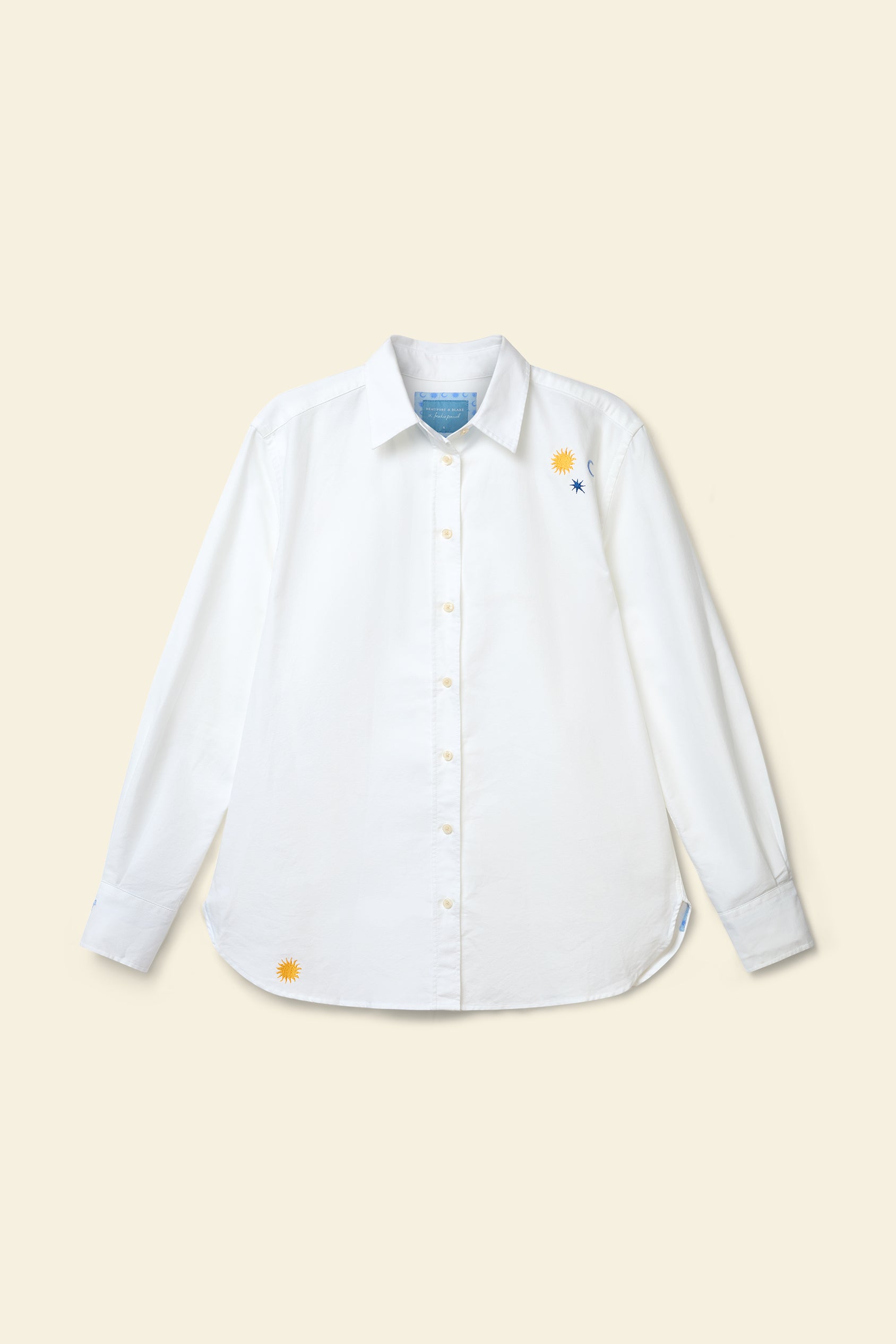 White shirt with colorful buttons on a beige background