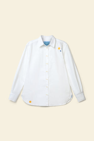 White shirt with colorful buttons on a beige background