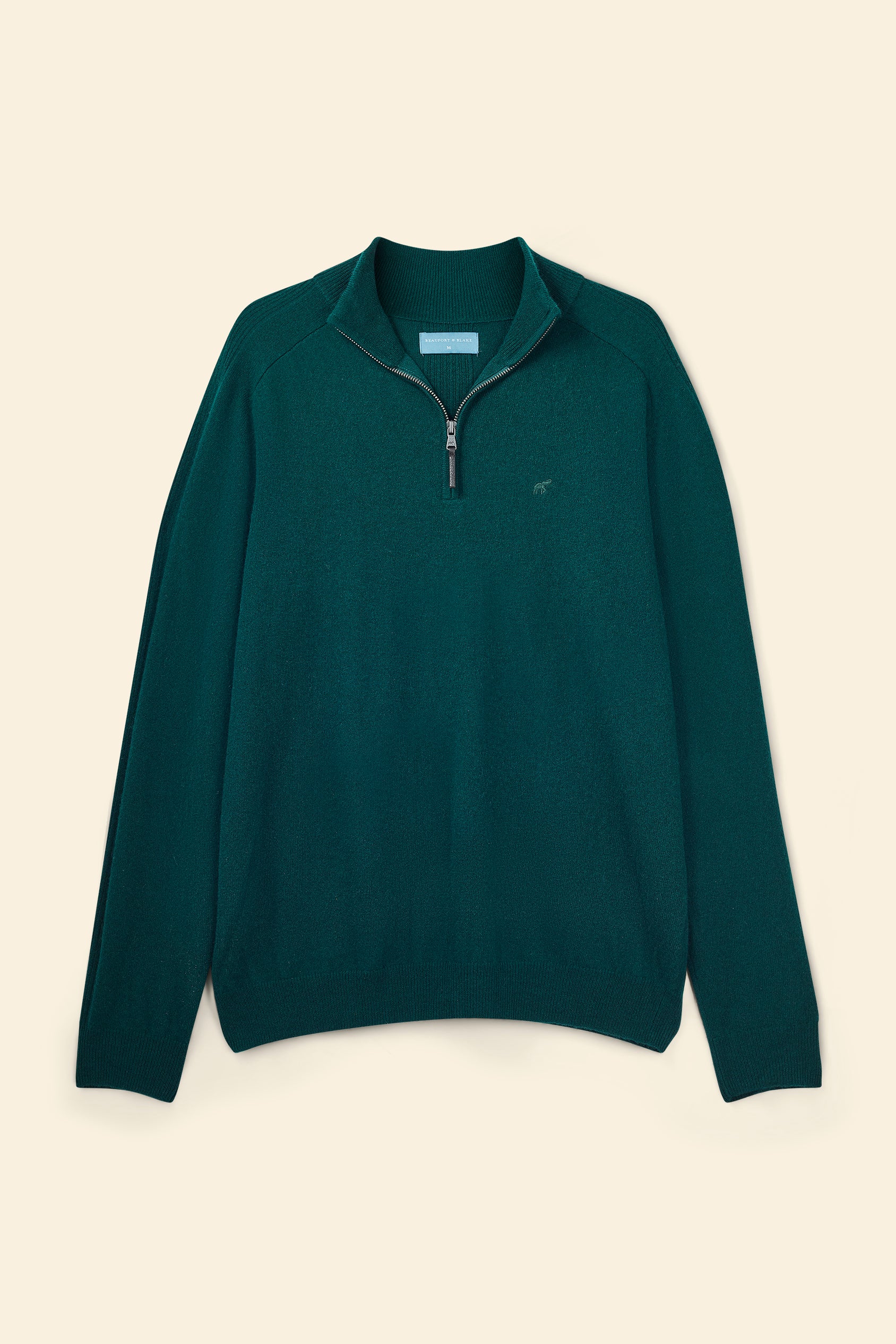 Green pullover with a zipper on a beige background