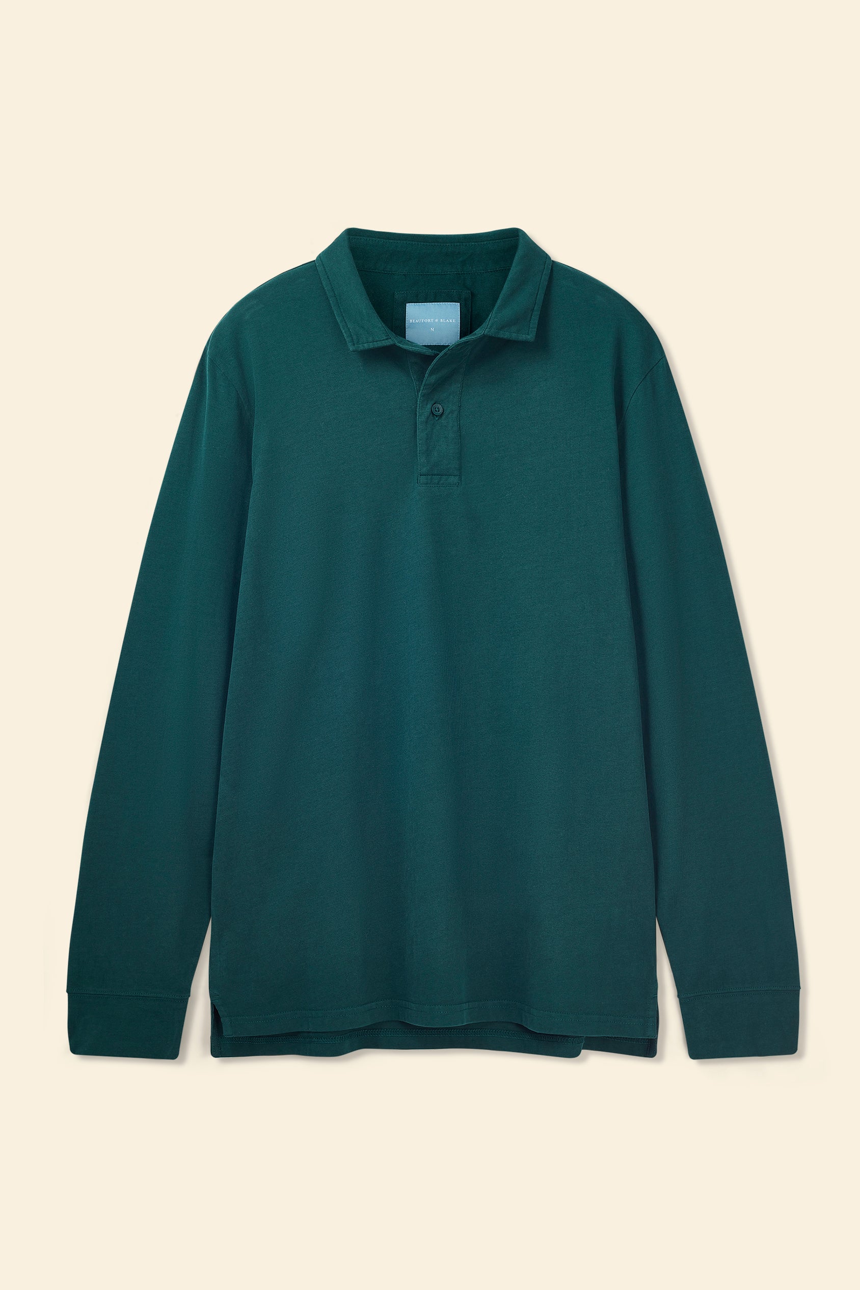 Green long-sleeve polo shirt on a beige background