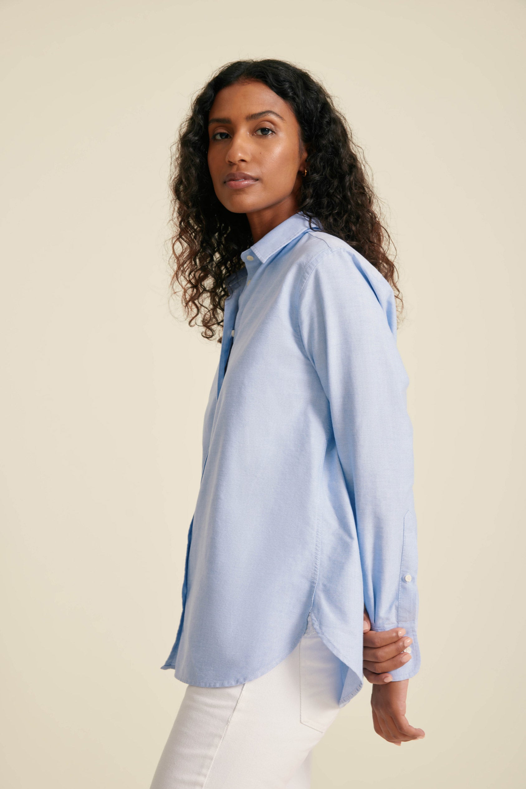 Woman wearing a light blue shirt against a beige background