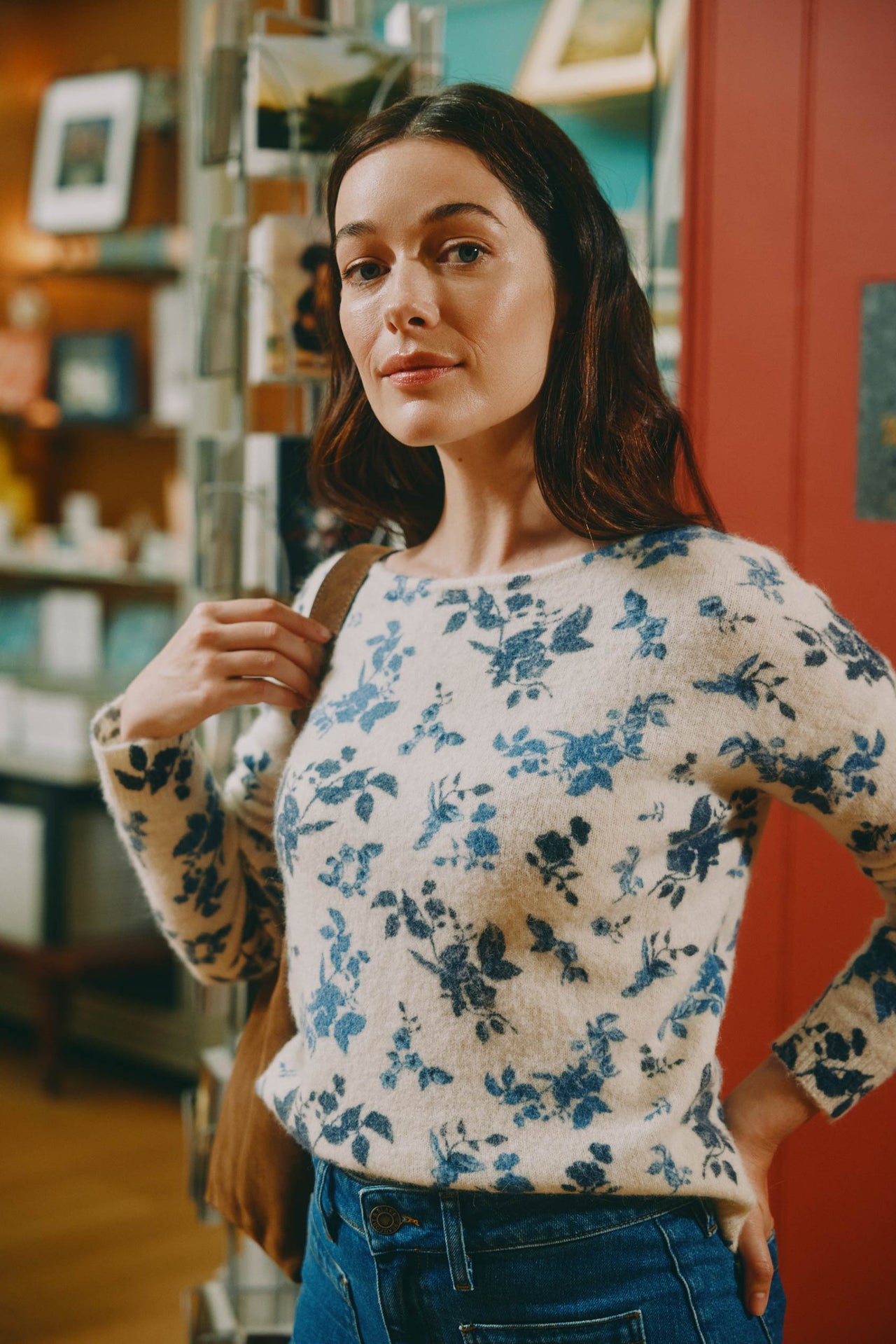 Woman wearing a floral sweater in a store setting
