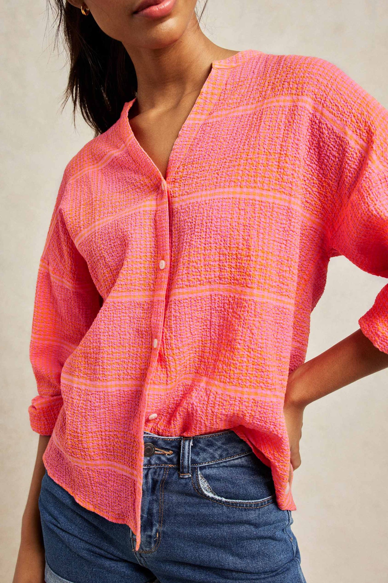 Textured seersucker gingham shirt with Nehru collar. Cut from seersucker cotton and patterned with vibrant orange and pink checks. An effortless boyfriend fit with drop shoulders and blouson sleeves. Casual wear. Size XS, S, M, L, XL. Made in Portugal. Machine wash.