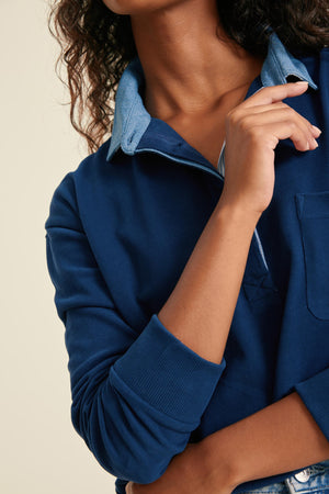 Person wearing a blue shirt with a neutral background