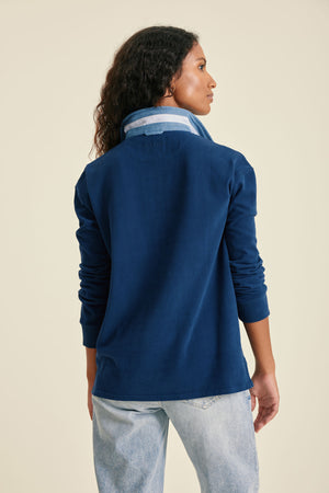 Woman wearing a blue jacket with a beige background