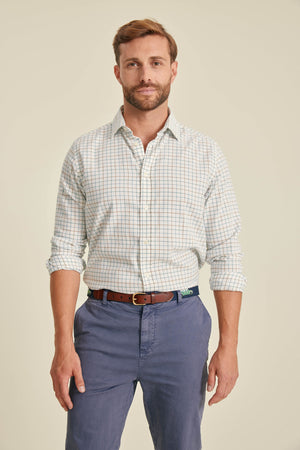 Man wearing a checkered shirt and blue pants on a beige background