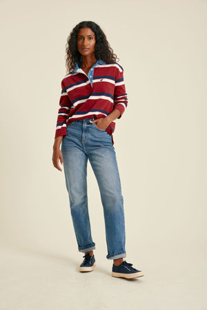 Woman wearing a striped sweater and jeans on a beige background