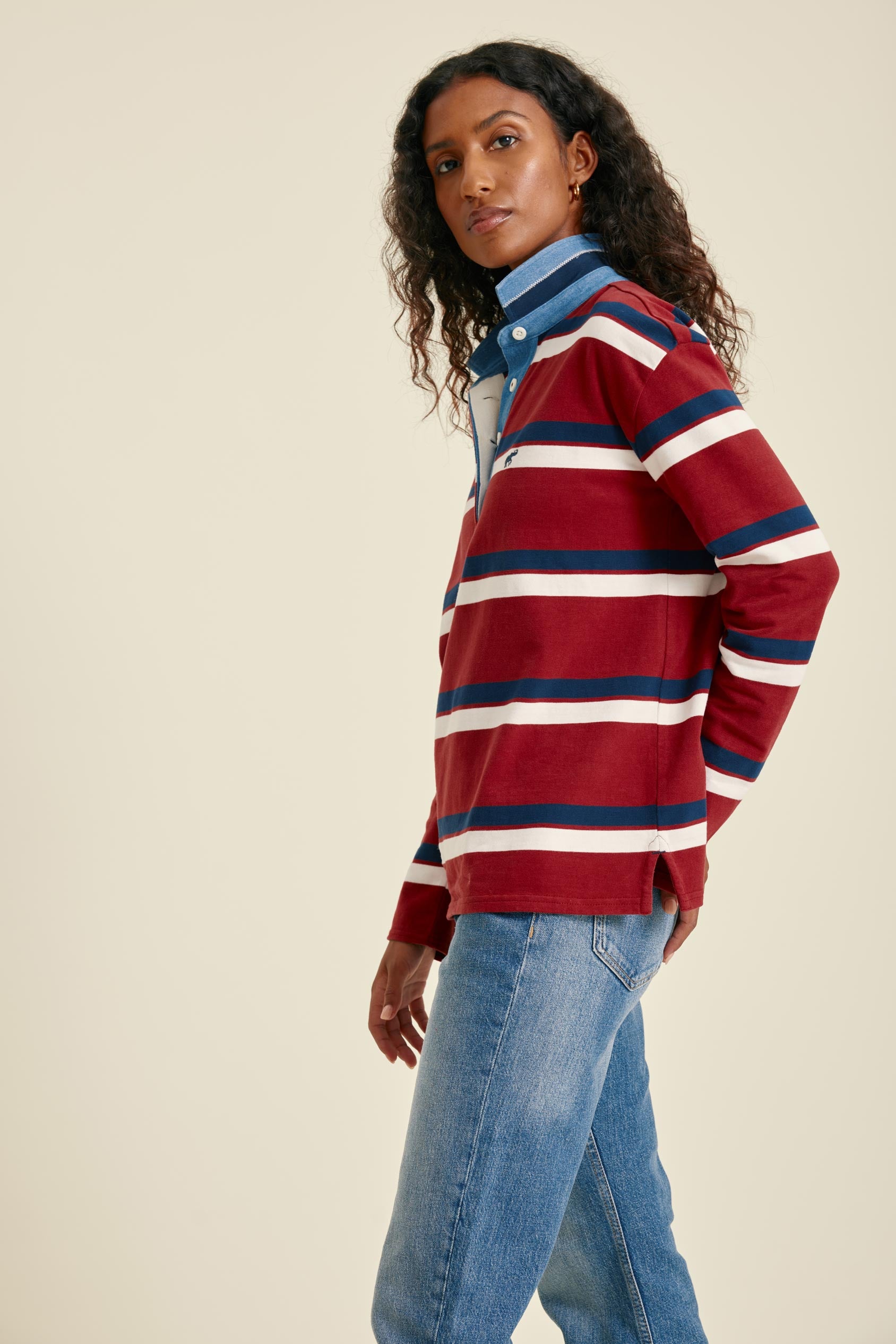 Woman wearing a red and blue striped sweater with a plain background