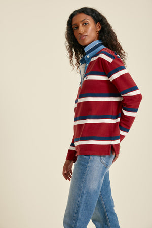Woman wearing a red and blue striped sweater with a plain background