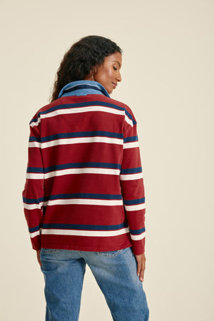 Person wearing a red, white, and blue striped sweater on a beige background