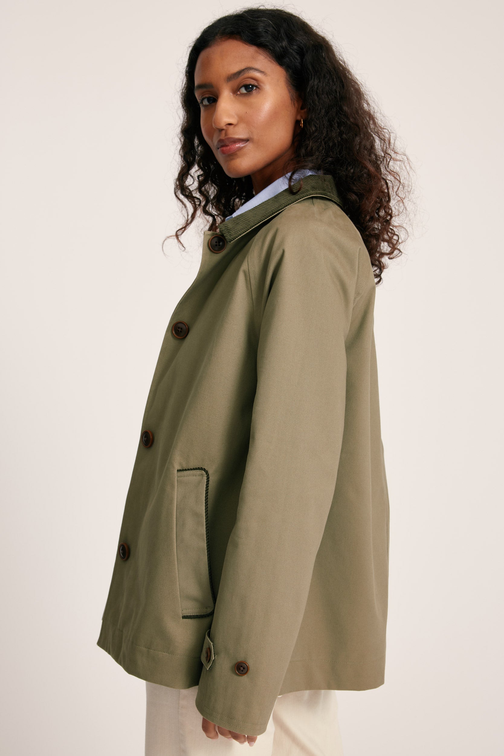 Woman wearing a green coat on a white background