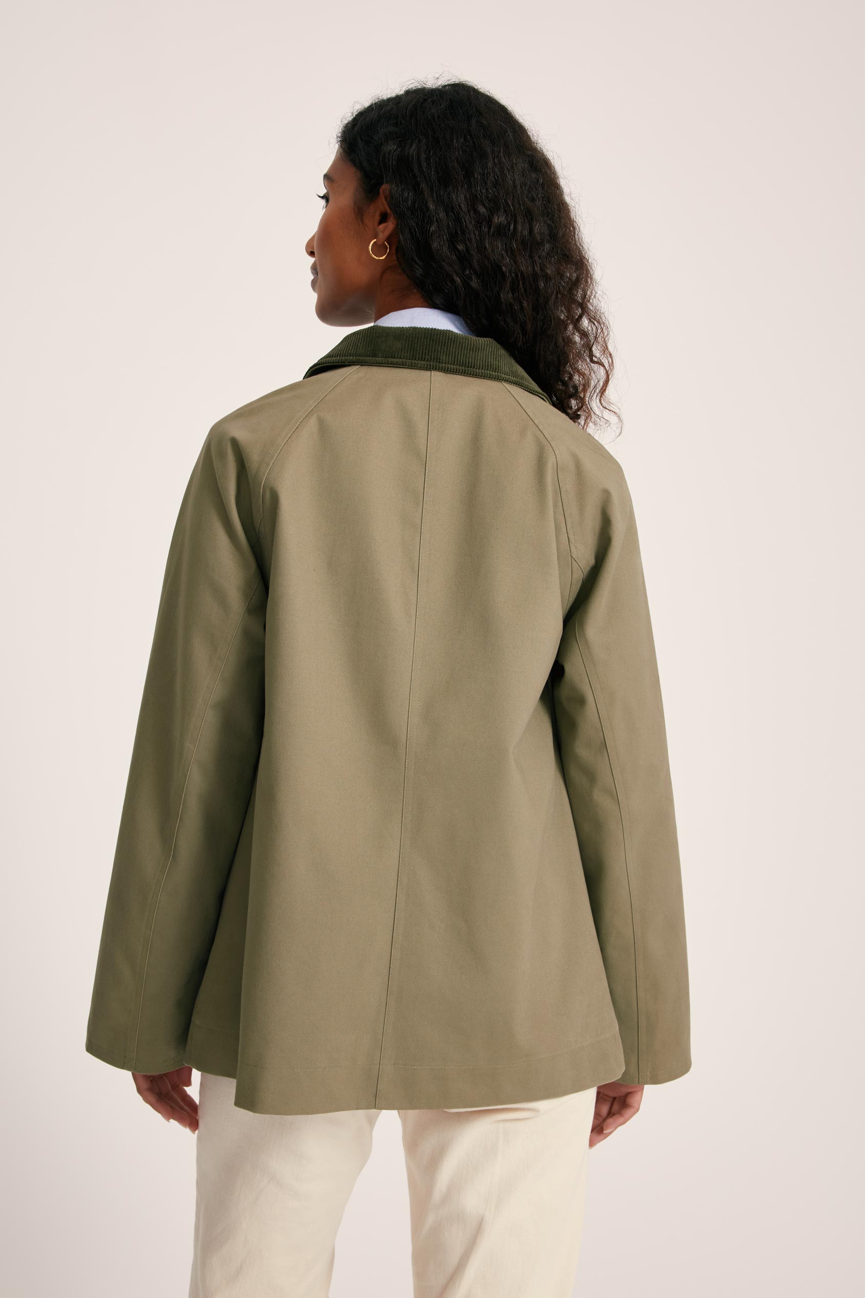 Person wearing a green jacket on a plain background