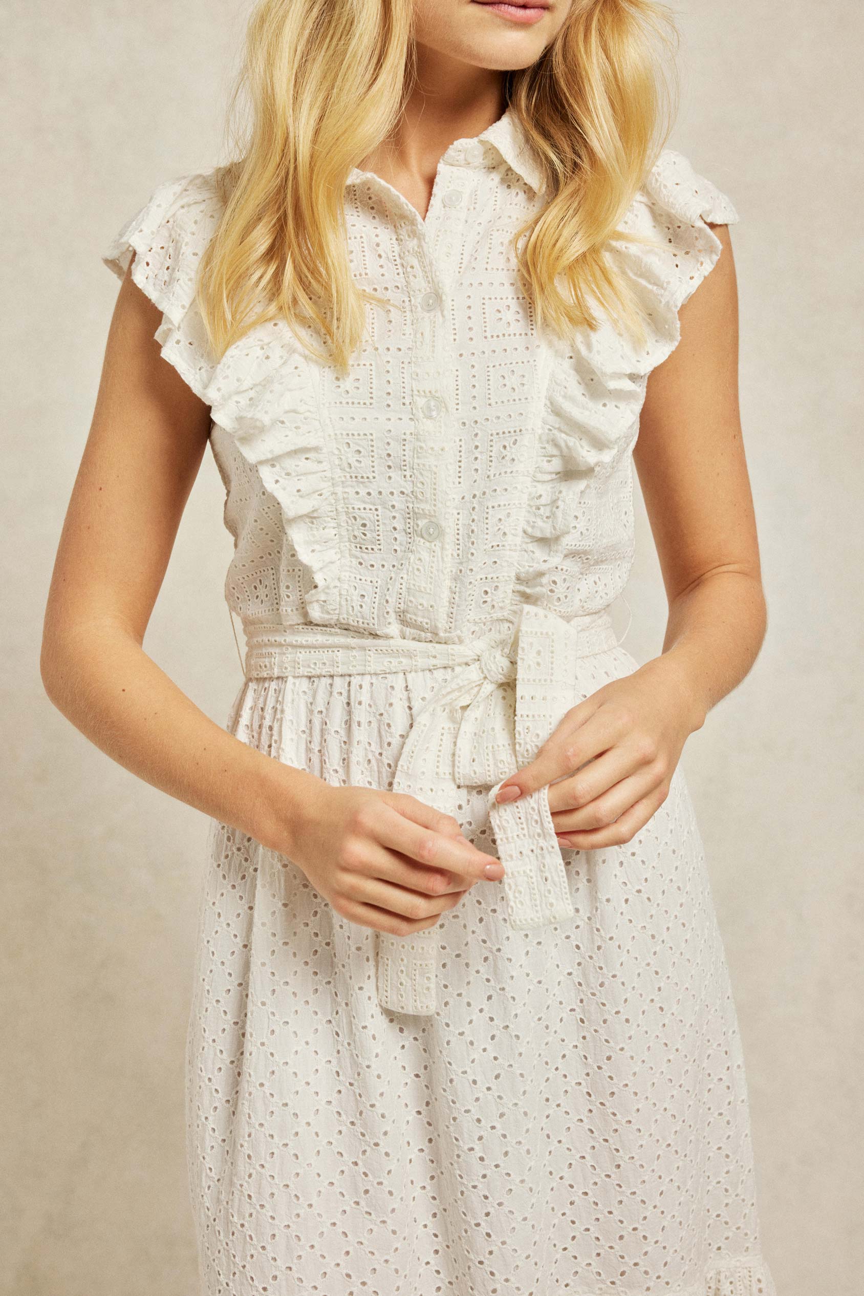 The Crocus features ruffles which trim the design, cut from traditional broderie anglaise and fitted with a self-tie waist. Smart casual wear. Summer dress. Size 6,8,10,12,14,16,18. Machine wash.