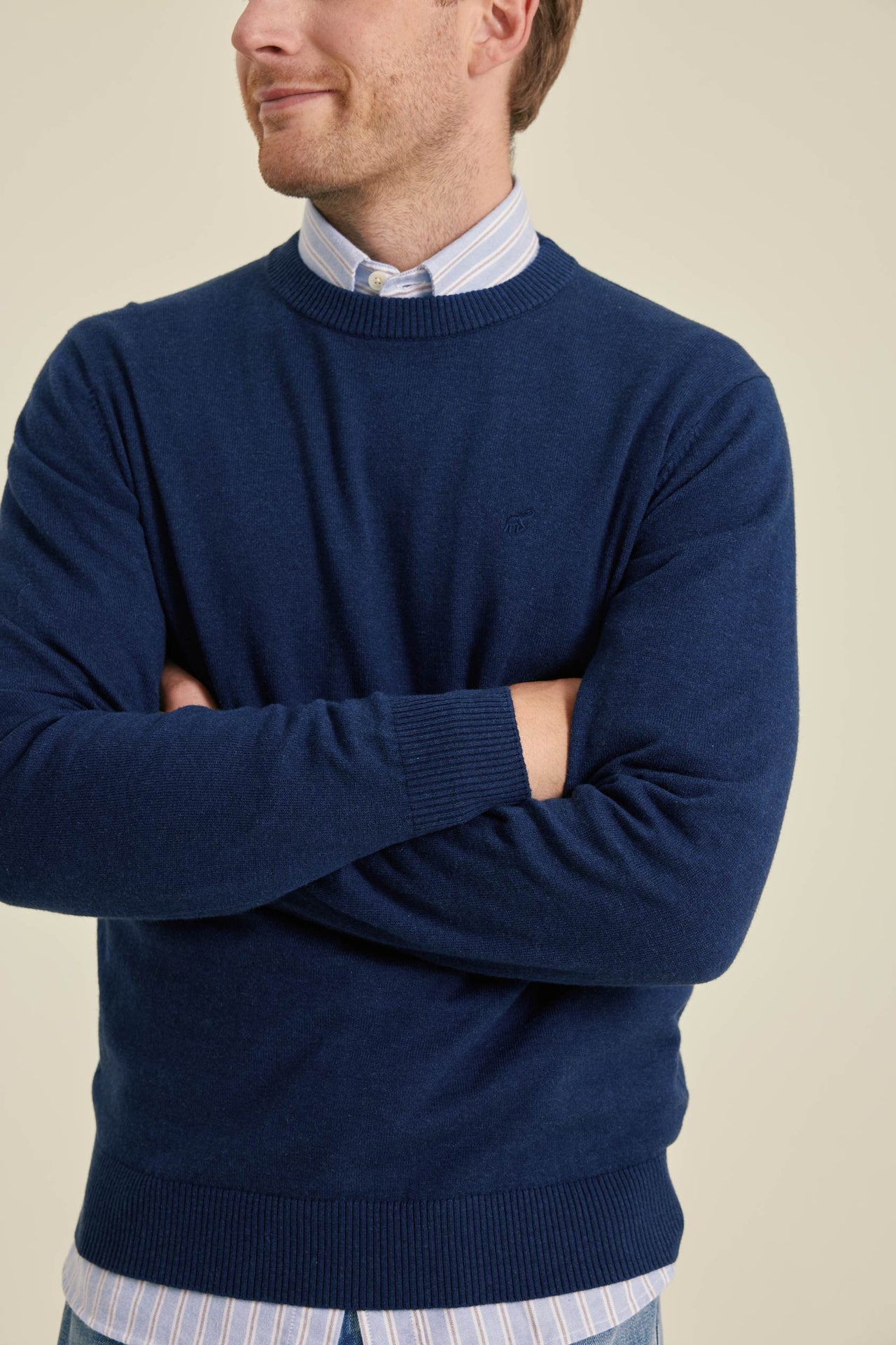 Man wearing a blue sweater with a plain background