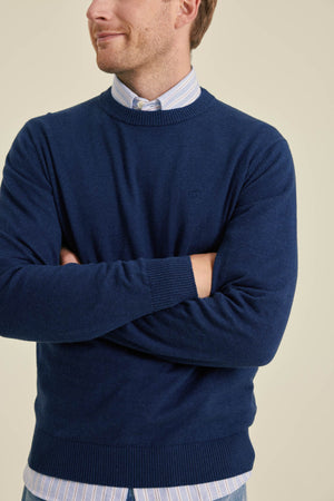 Man wearing a blue sweater with a plain background