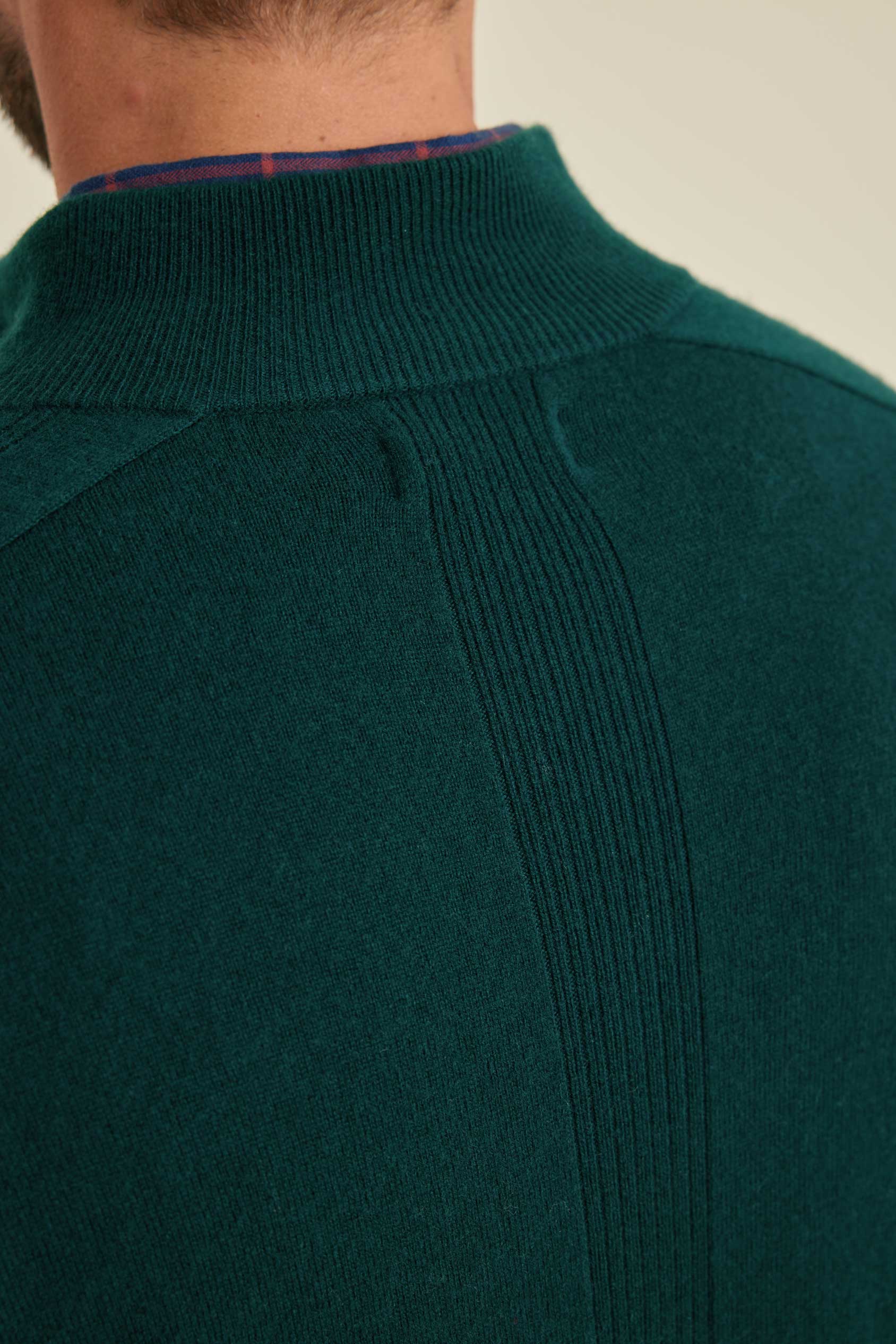 Close-up of a green sweater with a plain background