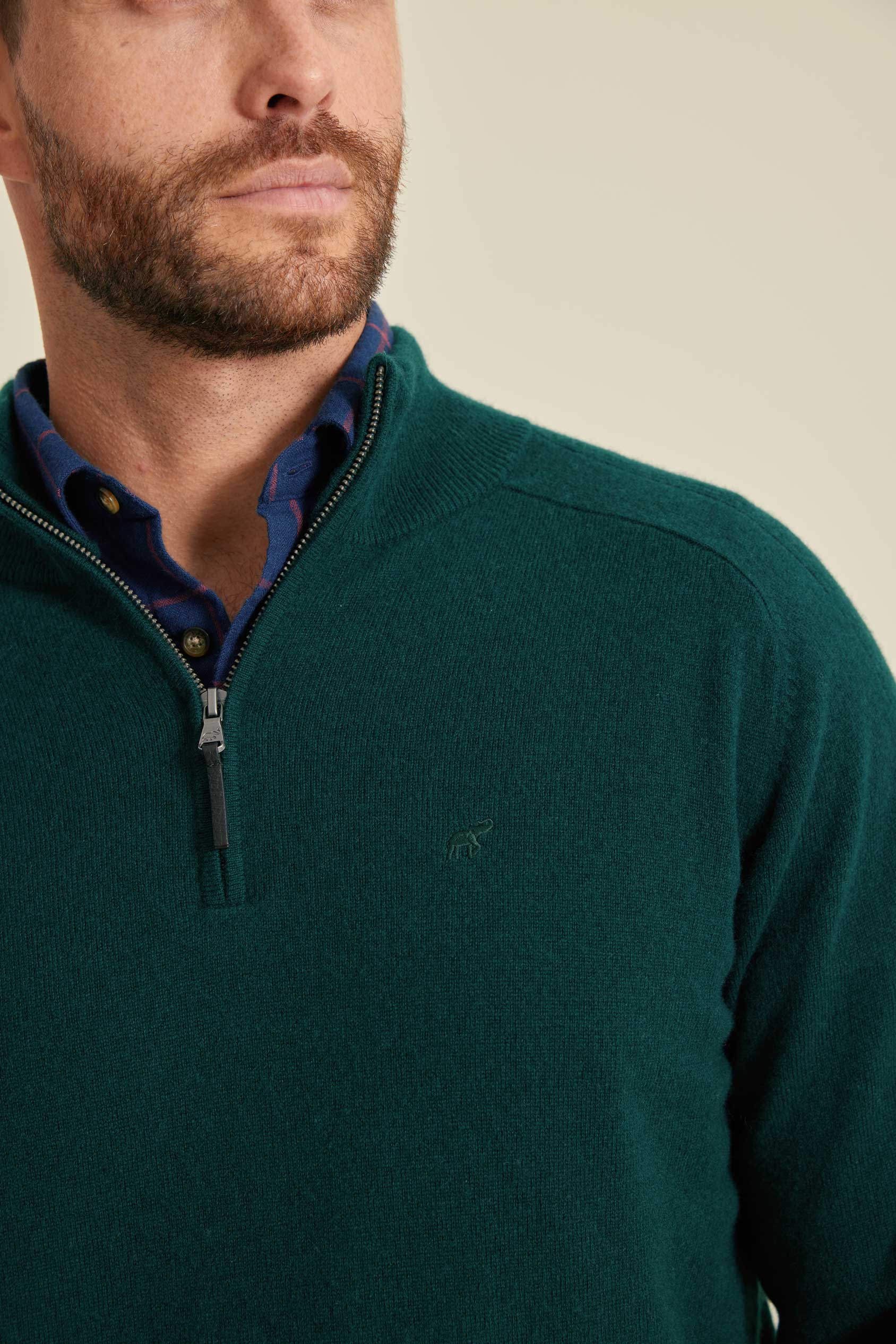 Man wearing a green sweater with a close-up of the collar and zipper.