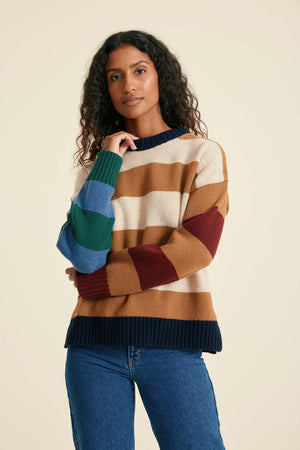 Woman wearing a colorful striped sweater against a beige background