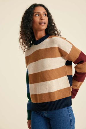 Woman wearing a multicolored striped sweater against a beige background