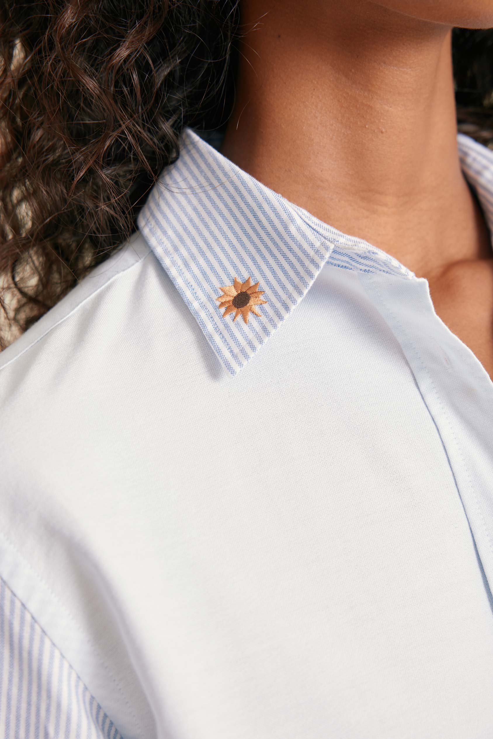 Close-up of a white shirt with a sunflower design on the collar