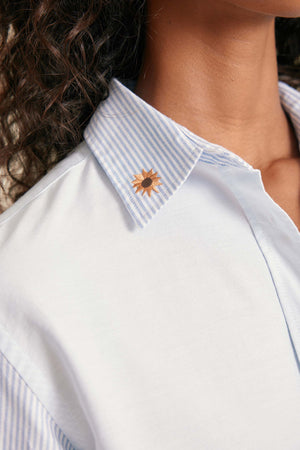 Close-up of a white shirt with a sunflower design on the collar