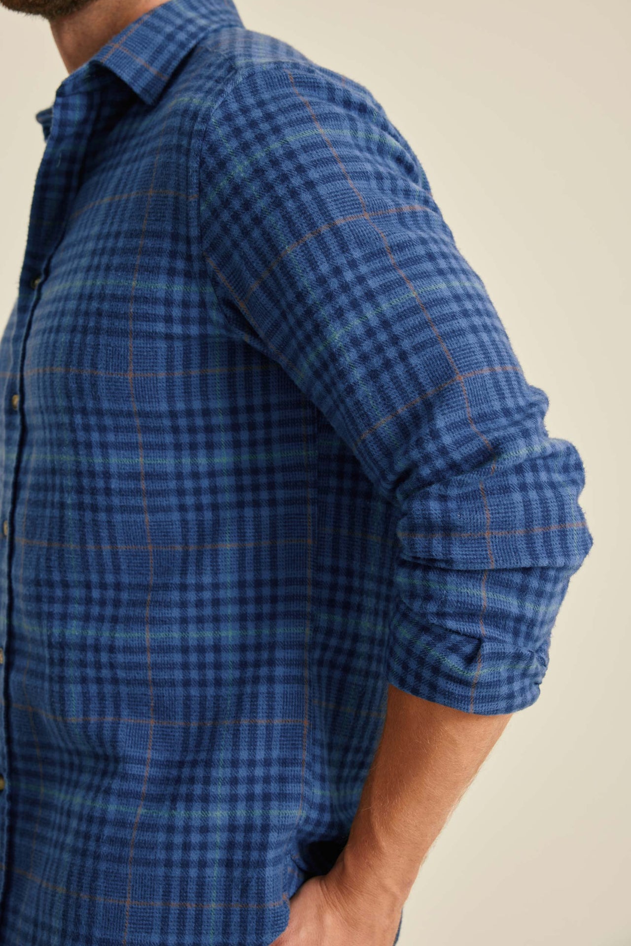 Blue plaid shirt worn by a person on a beige background