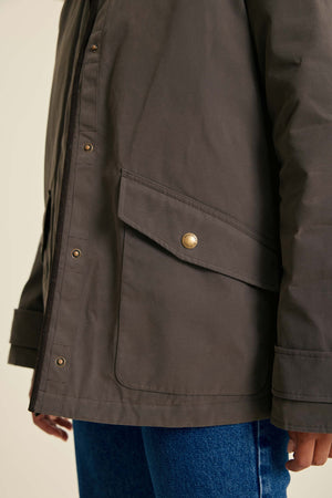 Dark jacket with a pocket and button on a neutral background