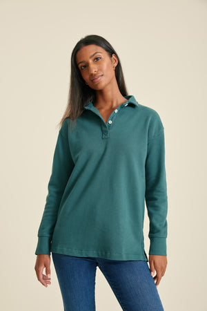 Woman wearing a pine sweat with buttons on a beige background