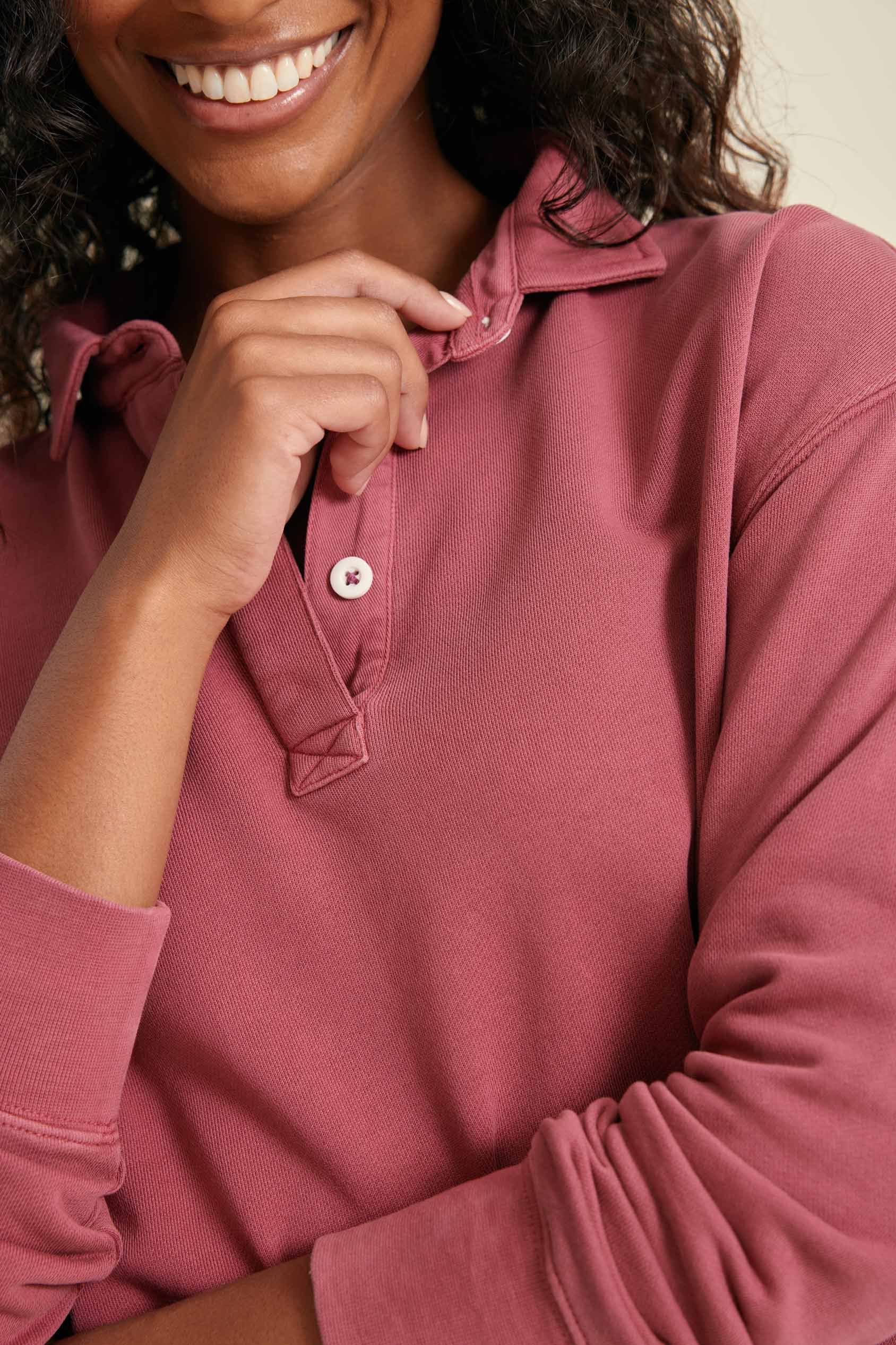 Person wearing a pink long-sleeve sweat with a close-up of the collar.