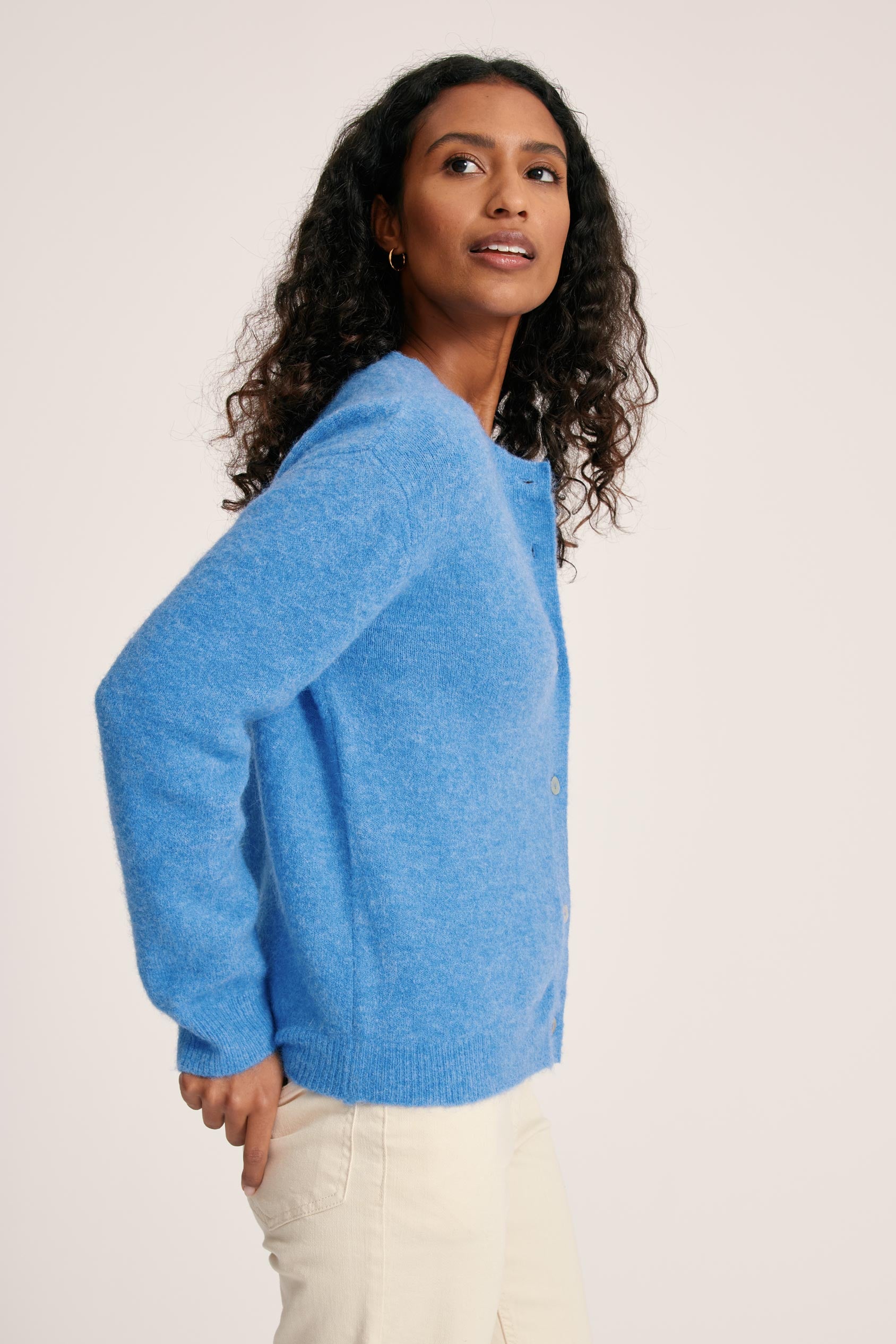 Woman wearing a blue sweater against a plain background
