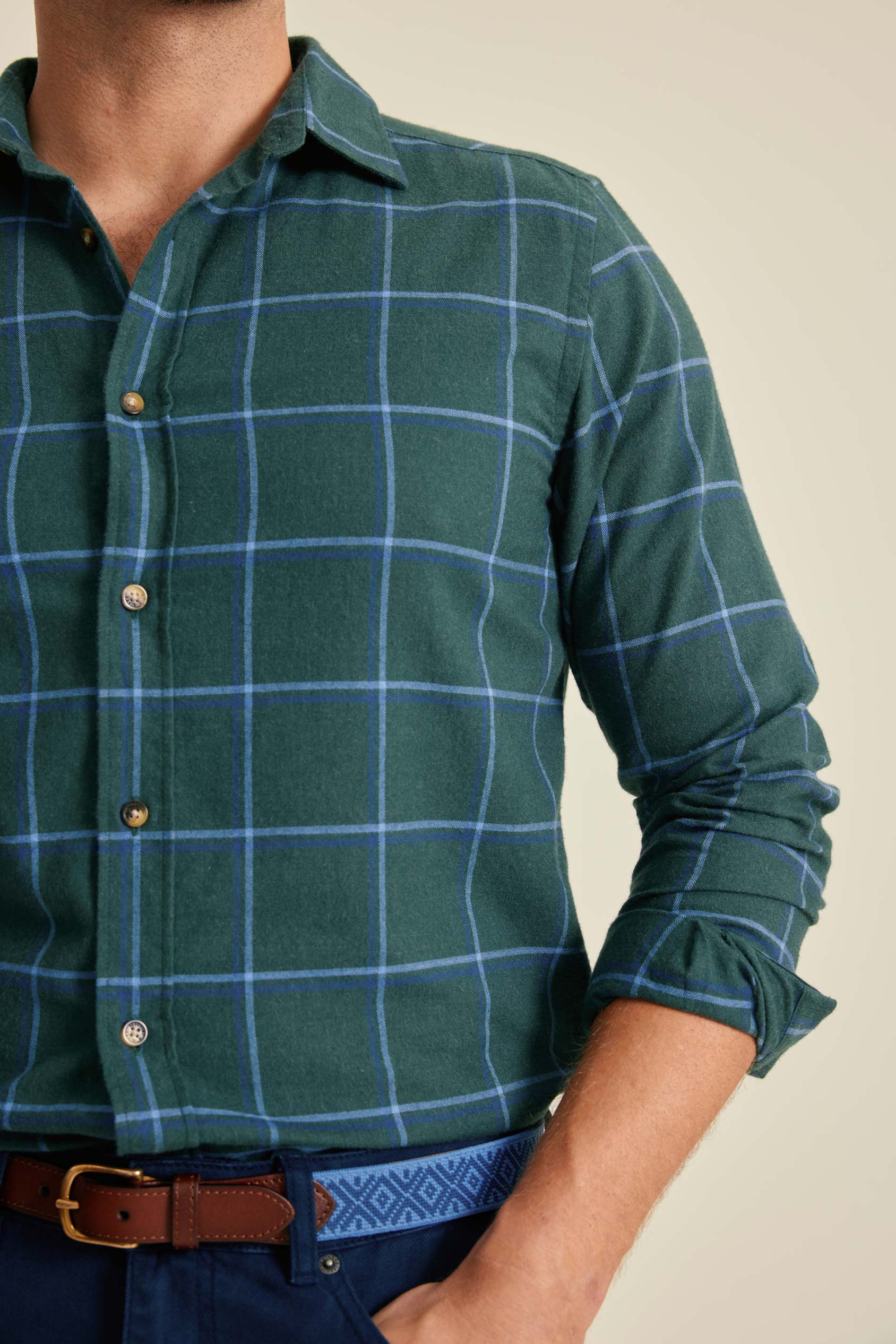 Green checkered shirt worn by a person with a beige background