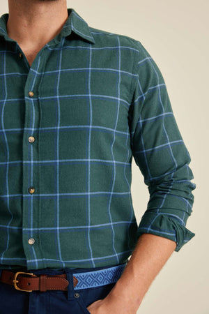 Green checkered shirt worn by a person with a beige background
