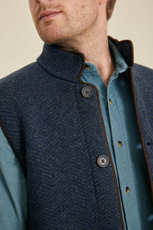 Man wearing a blue textured gilet with a beige background