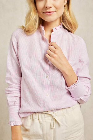 Soft ruffles add a hint of romance to this pink women’s ruffle linen shirt. Cut from breathable linen, patterned with subtle pastel-pink stripes, and dotted with cream buttons. Boyfriend fit. Casual wear. Size XS, S, M, L, XL. Made in Portugal. Machine wash.
