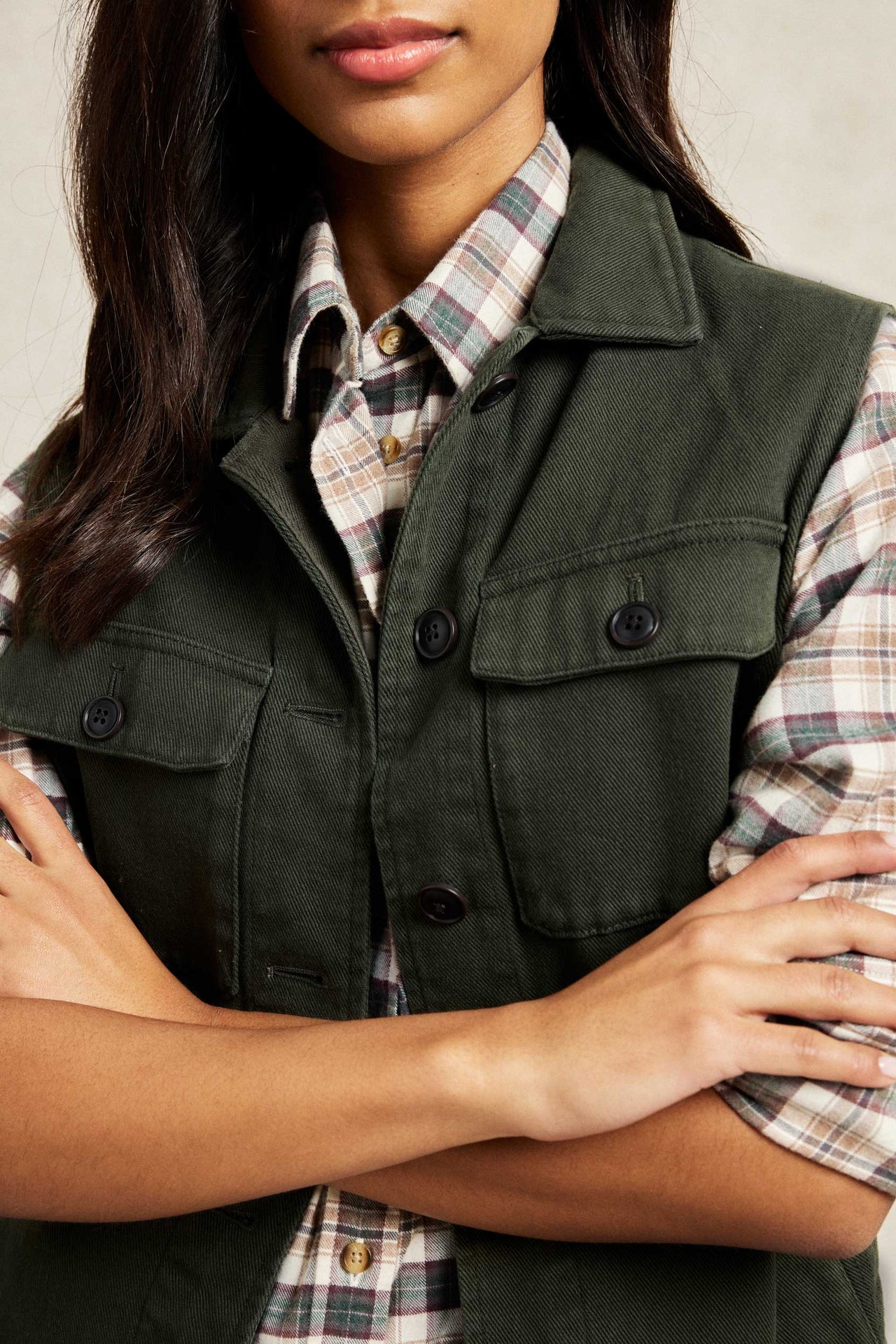 Button through khaki green women’s gilet with peached fabric finish. 100% Cotton. Brown buttons on front and chest pockets. Casual wear. Good for layering. Size XS, S, M, L, XL. Machine wash.