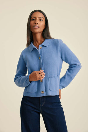 Woman wearing a blue jacket with a beige background