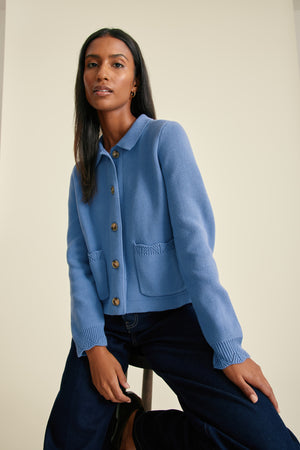 Woman wearing a blue jacket with a neutral background