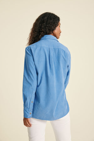Woman wearing a blue shirt against a beige background