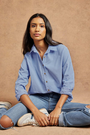 Fine needle cord women’s cornflower blue shirt with a back box pleat and curved hem for ease. 100% Cotton. Cut from soft needlecord to a classic fit with vintage buttons. Casual wear. Size XS, S, M, L, XL. Made in Portugal. Machine wash. Boyfriend fit.