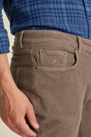 Brown corduroy pants with a brand logo on the pocket, worn with a blue plaid shirt.