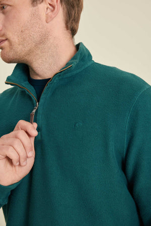 Man wearing a teal fleece jacket with a close-up of the zipper.
