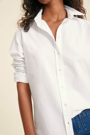 White button-up shirt worn by a person with a neutral background