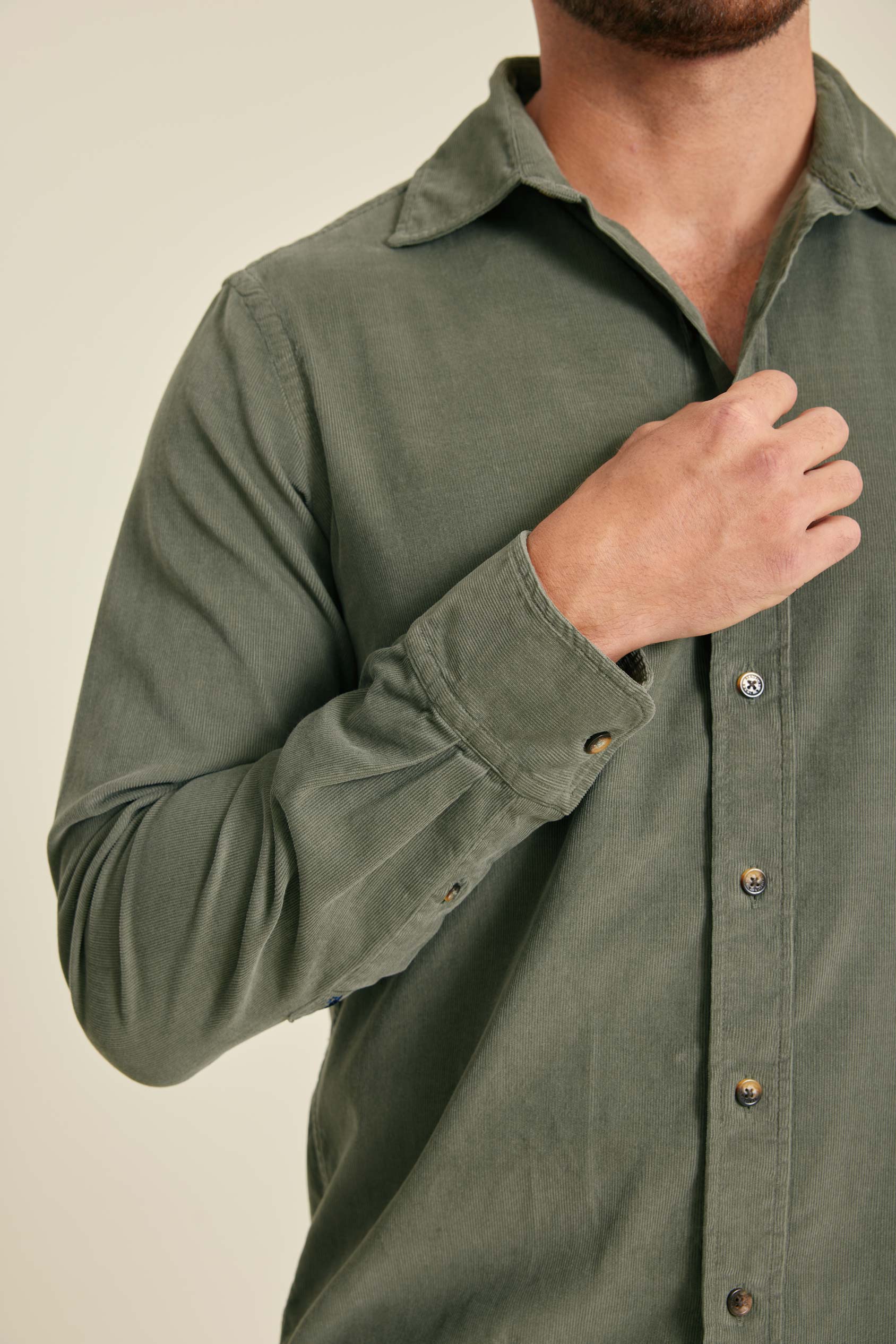 Green shirt worn by a person on a beige background